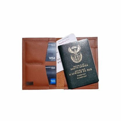 Inside view of leather passport holder and travel wallet, showcasing a passport, boarding pass and bank cards.