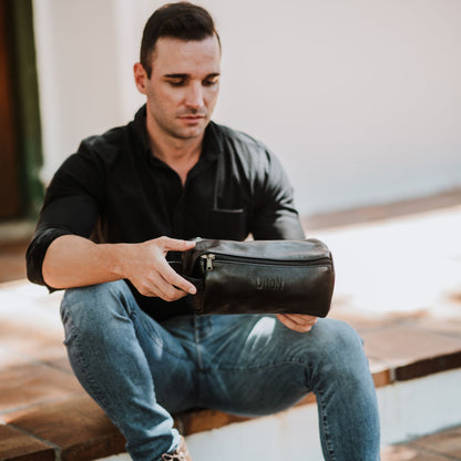 Front view of the leather toiletry bag, showcasing the handle and top zipper.