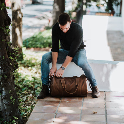 Front view of leather duffel bag, showcasing the handles and shoulder strap.