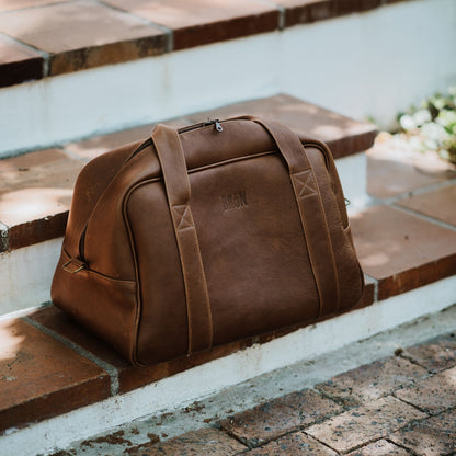 Side and front view of premium leather travel bag, made from the finest quality leather with added padding. It has an exclusive look and luxurious feel.