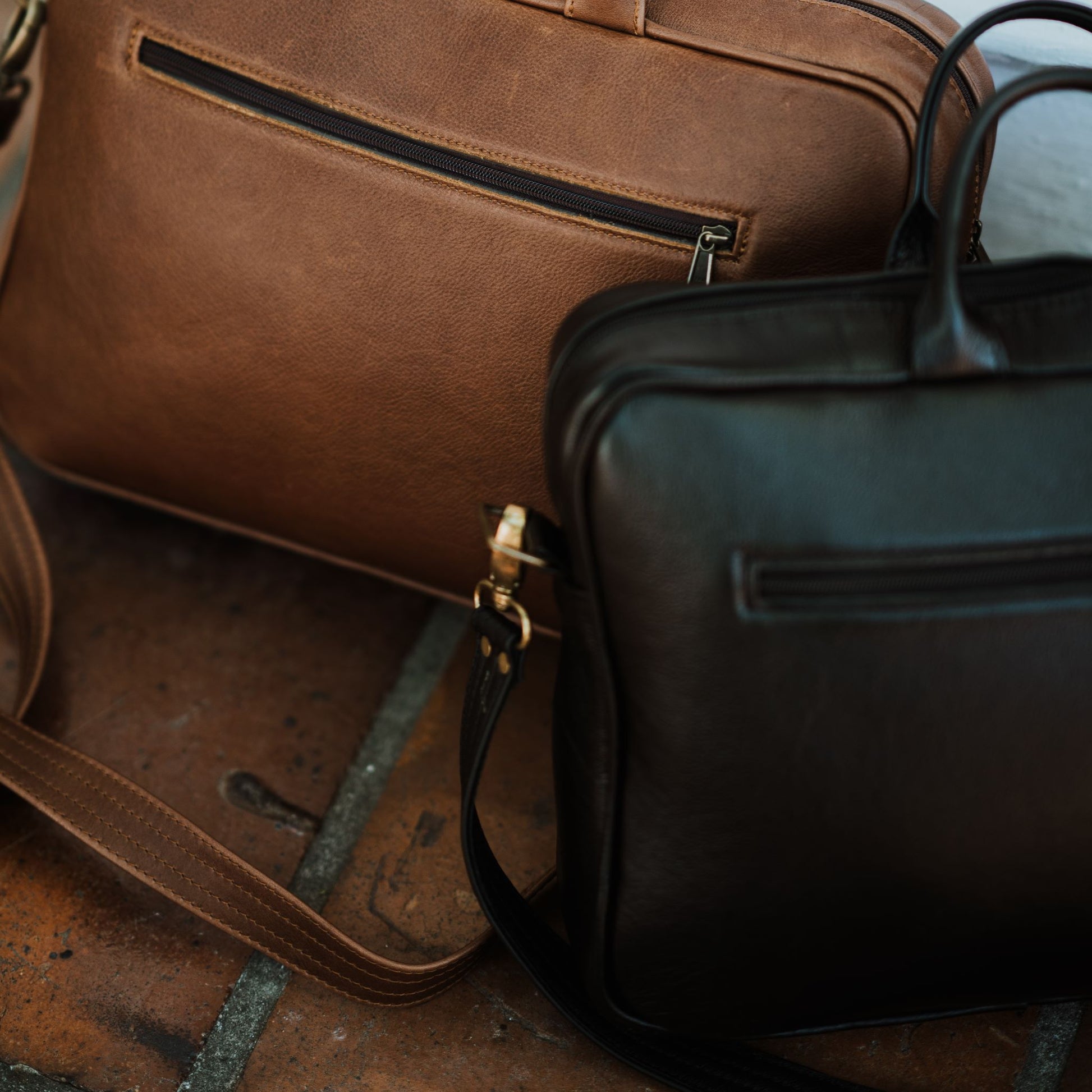 Back view of leather laptop bag, showcasing zip pocket and handles.