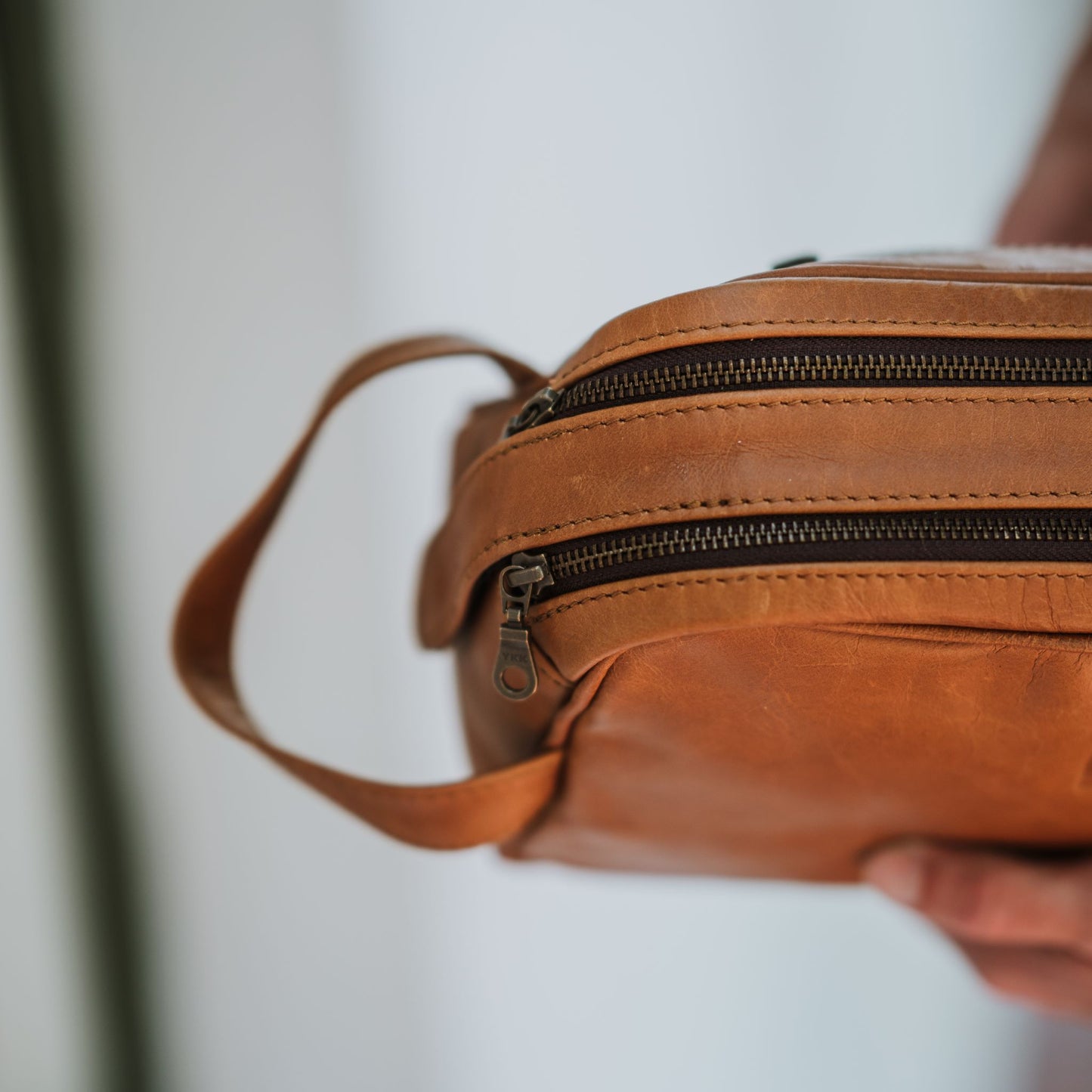 Top view of the leather toiletry bag, showcasing the handle and top zipper.