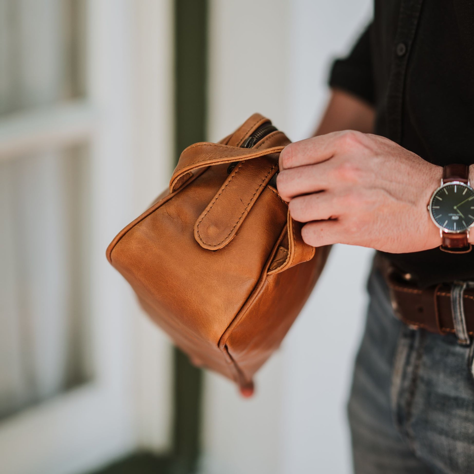 Side view of the leather toiletry bag, showcasing the handle.