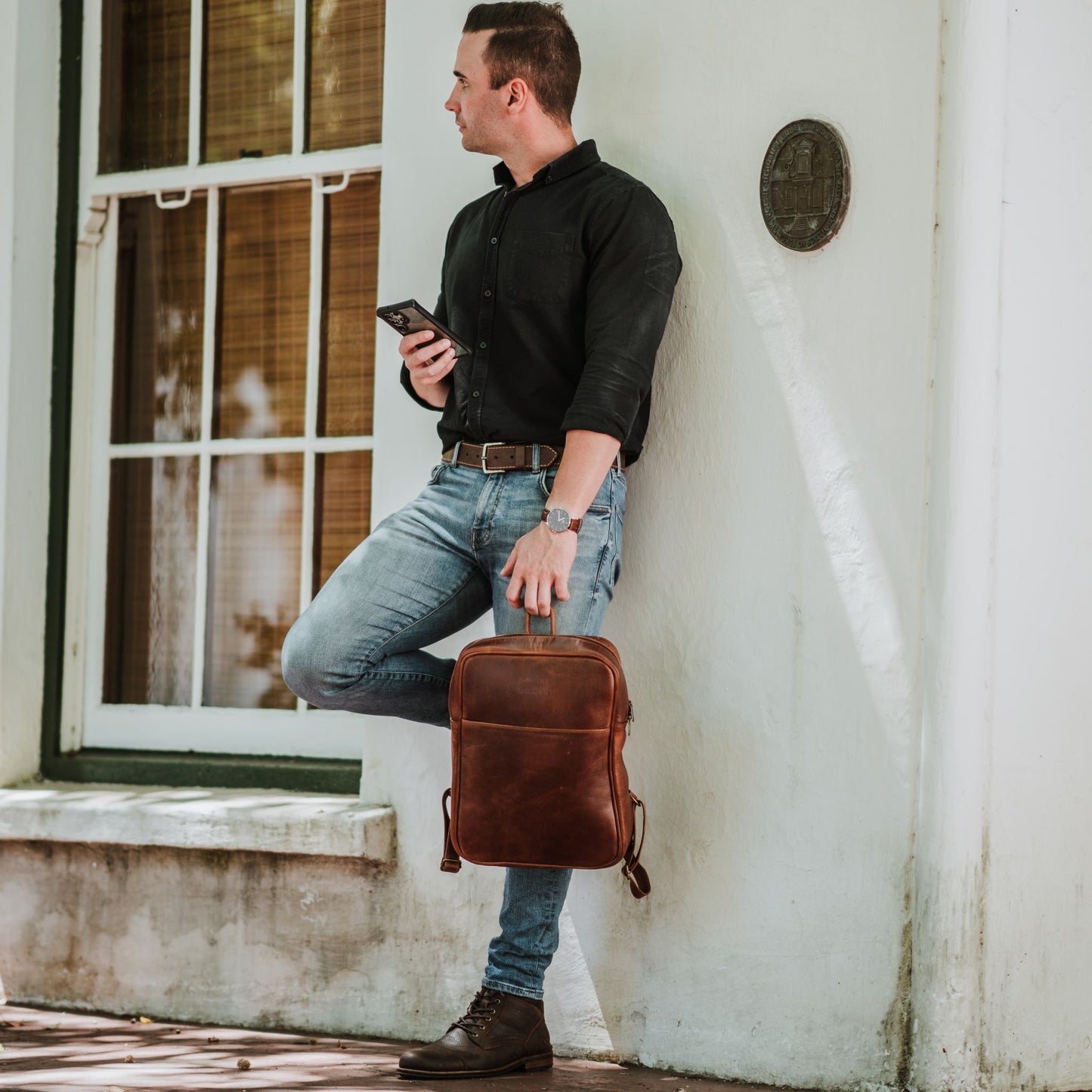 Front view of the leather laptop backpack, showcasing the front sleeve pocket.