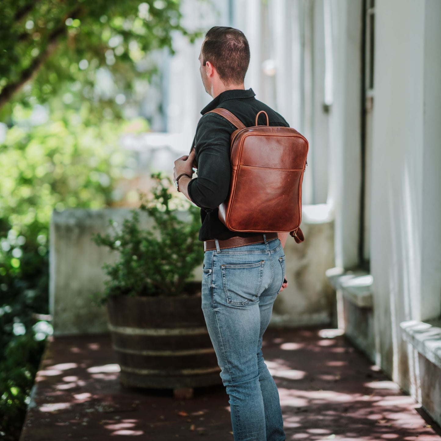 Front view of the leather laptop backpack, showcasing the front sleeve pocket.