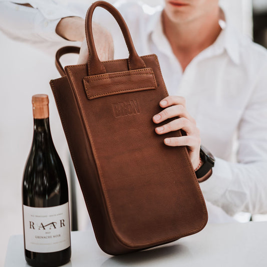 Front view of the leather wine carrier, showcasing the handles.