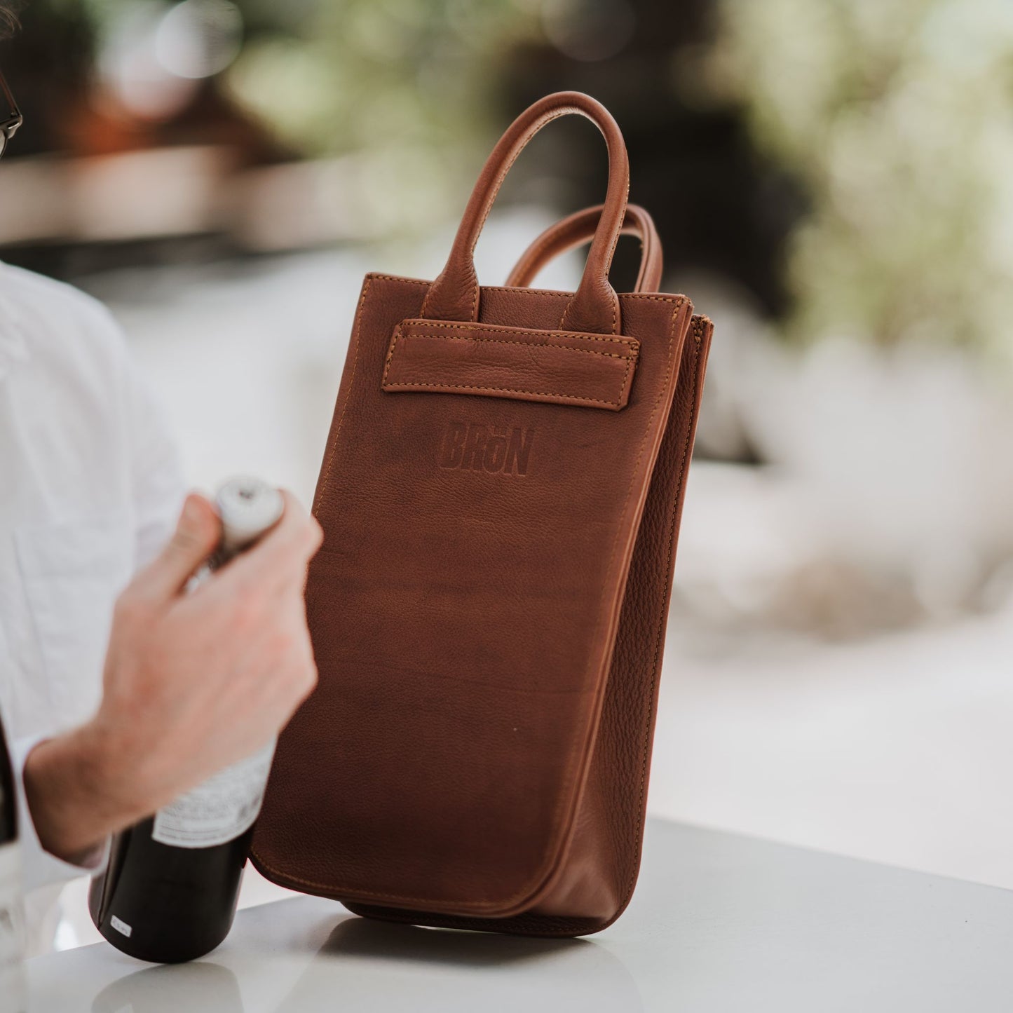 Front view of the leather wine carrier, showcasing the handles.