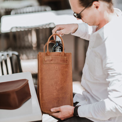 Front view of the leather wine carrier, showcasing the handles.