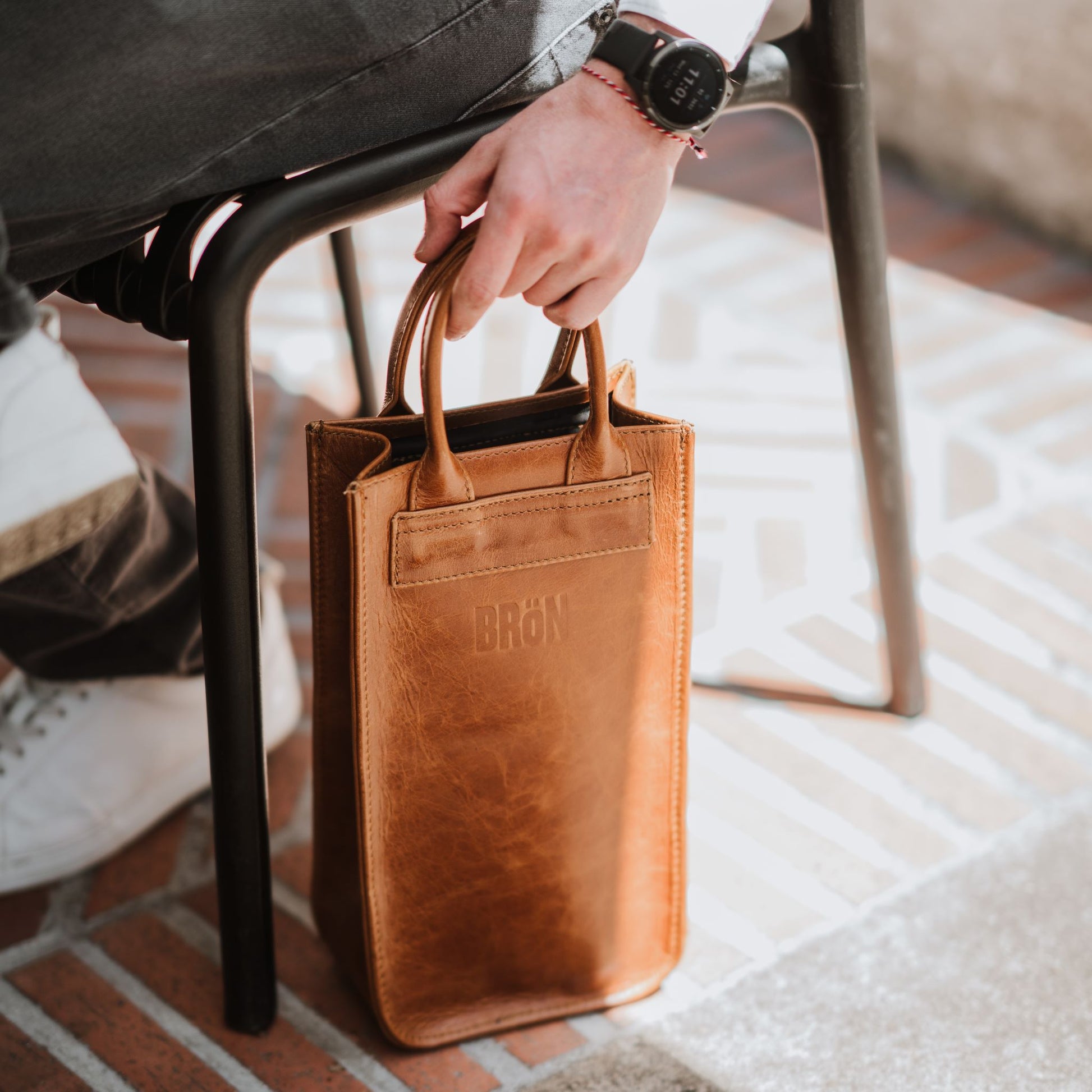 Front view of the leather wine carrier, showcasing the handles.