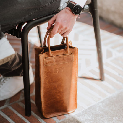 Front view of the leather wine carrier, showcasing the handles.