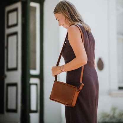 Front view of the leather sling bag, showcasing the adjustable shoulder strap.