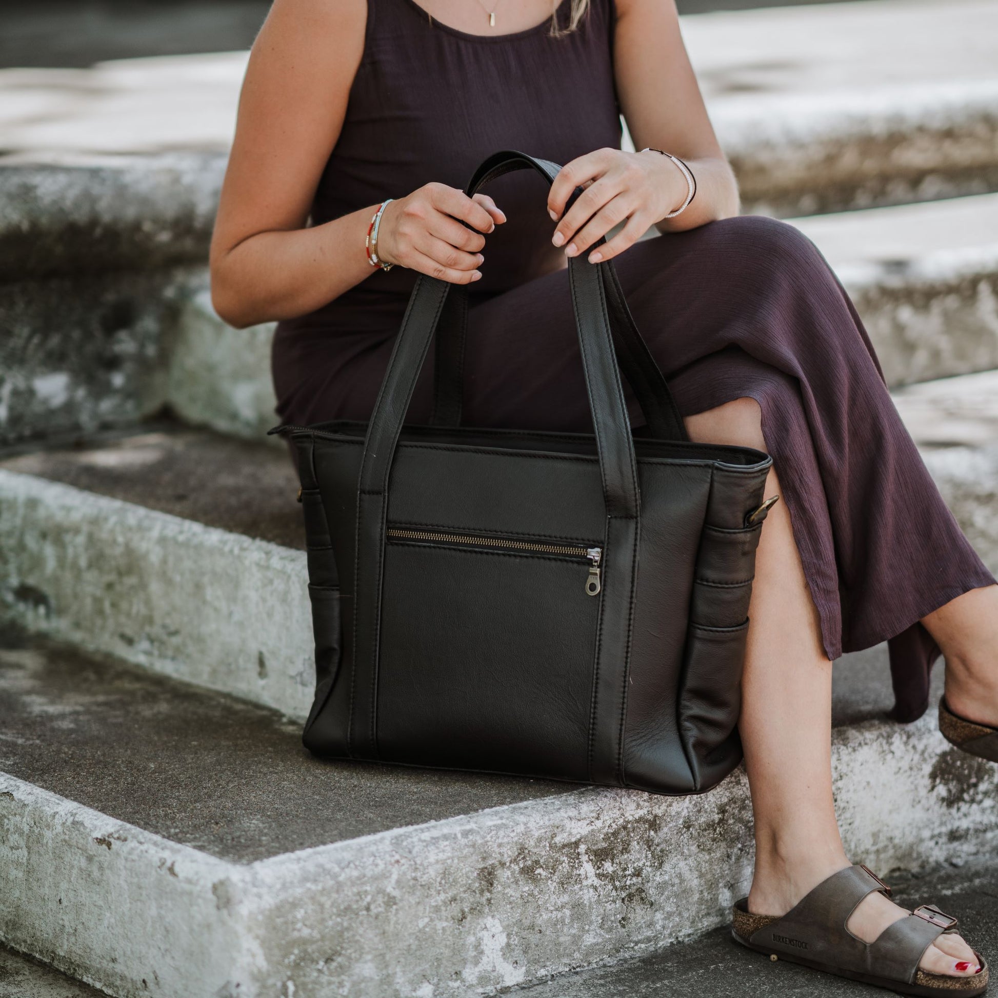 Back view of the leather laptop tote, showcasing the handles and back zip pocket..